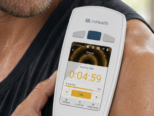 A miHealth device held against a man's shoulder, the Energy program running on screen